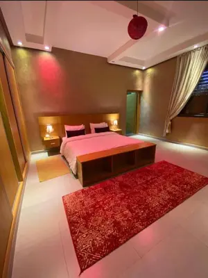 a bedroom with a bed and a red rug at Villa Tounaroz in Marrakech