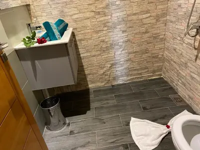 a bathroom with a toilet and a tiled floor at Villa Tounaroz in Marrakech