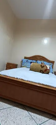 a bedroom with a large bed with white sheets at belle vue in Meknès