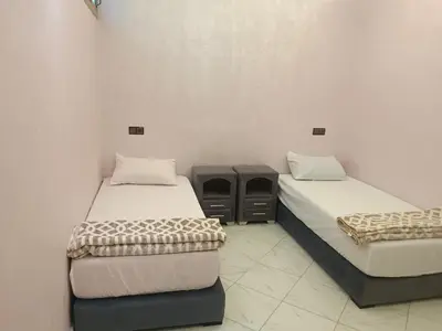 a room with two beds and a table in it at Dakhla in Oulad Akkou