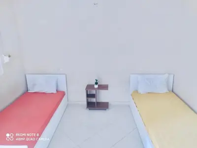 two beds in a white room with a table at Riad ezzaytoune 2 in Meknès