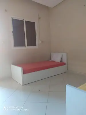 a bed in a white room with a red mattress at Riad ezzaytoune 2 in Meknès