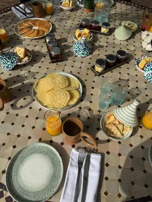 a table with plates of food on a tiled floor at Le mas de l'Ourika, maison d'hôtes in Aït Zat