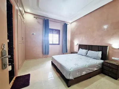 a bedroom with a large bed with blue curtains at Hotel&Restaurant Atlas Symphony in Ourika