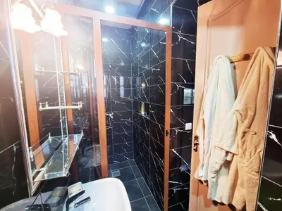 a bathroom with black tiled walls and a shower at Hotel&Restaurant Atlas Symphony in Ourika