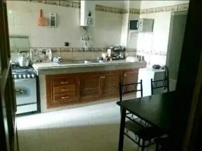 a kitchen with a sink and a stove and a table at Apparemment Mehdi in Fès