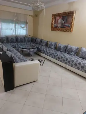 a living room with a large couch and a table at Apparemment Mehdi in Fès