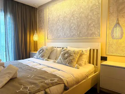 a bedroom with a bed with a painting on the wall at New appart moderne à Gueliz , charme et confort in Oulad Akkou