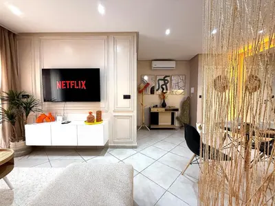 a living room with a tv on a wall at New appart moderne à Gueliz , charme et confort in Oulad Akkou