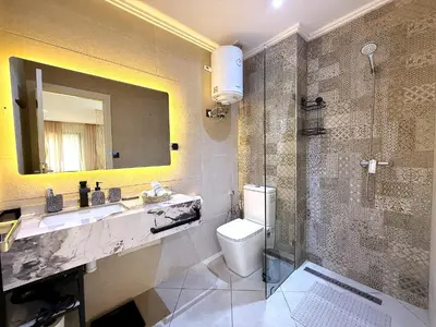 a bathroom with a toilet and a sink and a shower at New appart moderne à Gueliz , charme et confort in Oulad Akkou