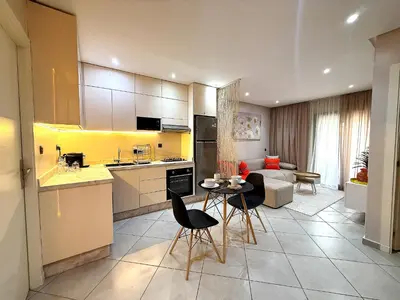 a kitchen and living room with a table and chairs at New appart moderne à Gueliz , charme et confort in Oulad Akkou