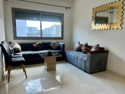 a living room with a blue couch and a mirror at Residence Noor - Central Apartments Fes in Fès