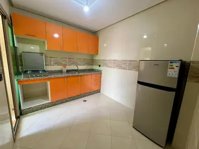 a kitchen with orange and white cabinets and a refrigerator at Residence Noor - Central Apartments Fes in Fès