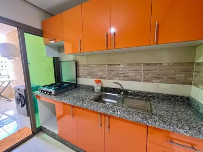 a kitchen with orange cabinets and a sink at Residence Noor - Central Apartments Fes in Fès