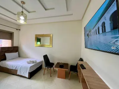 a hotel room with a bed and a tv at Residence Noor - Central Apartments Fes in Fès