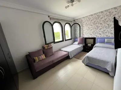 a room with two beds and a couch and windows at كابو نيكرو in Oulad Akkou