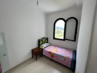 a small bedroom with a small bed and a mirror at كابو نيكرو in Oulad Akkou