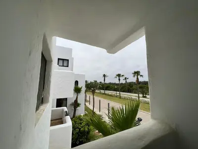 a view from the hallway of a white building with palm trees at كابو نيكرو in Oulad Akkou