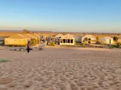 a person standing in the middle of a desert at Desert Campo in Oulad Akkou
