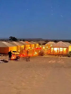 a group of buildings in the desert at night at Desert Campo in Oulad Akkou