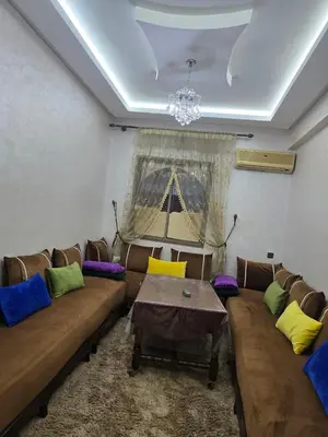 a living room with a couch and a table at Apparemment pour vacances in Oulad Akkou