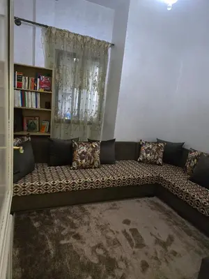 a couch with pillows sitting in a living room at Apparemment pour vacances in Oulad Akkou
