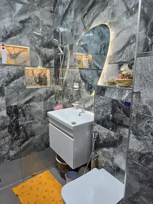 a bathroom with a white toilet and a rock wall at Apparemment pour vacances in Oulad Akkou