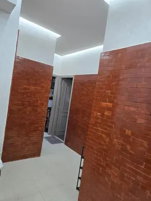 a room with a brick wall and a chair at Apparemment pour vacances in Oulad Akkou