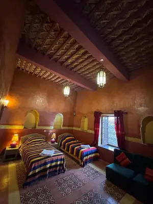 a large room with two beds and a couch at Hotel Kasbah Fenguig in Er Rachidia