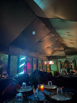a dining room with tables in a tent at Hotel Kasbah Fenguig in Er Rachidia