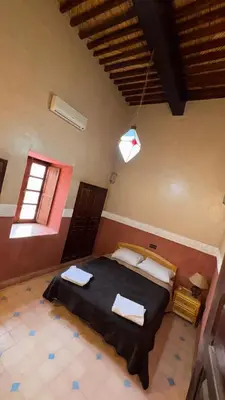 a bedroom with a large bed in a room at Hotel Kasbah Fenguig in Er Rachidia