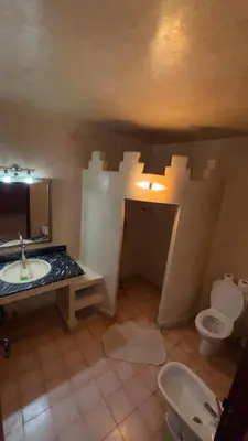 a bathroom with a toilet and a sink at Hotel Kasbah Fenguig in Er Rachidia