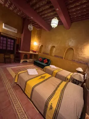 a bedroom with two beds in a room at Hotel Kasbah Fenguig in Er Rachidia