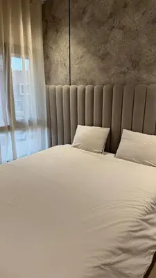 a bedroom with a large bed with white sheets and pillows at appartement Golf Prestigia 3 chambres in Oulad Akkou