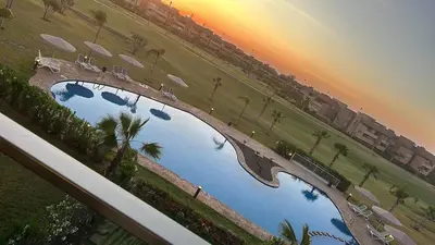 an overhead view of a pool with palm trees at appartement Golf Prestigia 3 chambres in Oulad Akkou