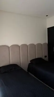 a bed in a room with a large headboard at appartement Golf Prestigia 3 chambres in Oulad Akkou
