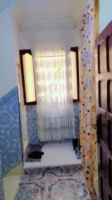 a room with a mirror and a wall with a window at appartement Tanger in Oulad Akkou
