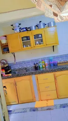 a kitchen with wooden cabinets and pots and pans at appartement Tanger in Oulad Akkou
