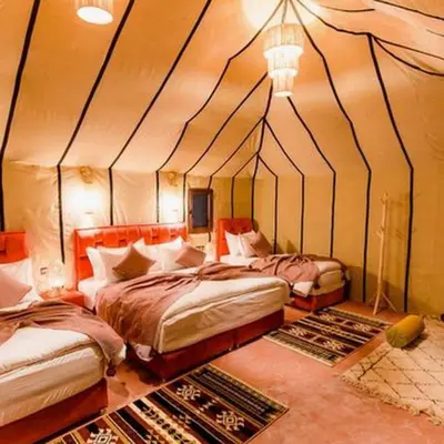 a bedroom with two beds in a tent at Desert Bloom Luxury Camp in Merzouga