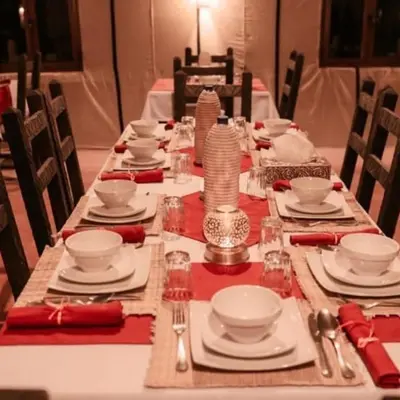 a long table with plates and dishes on it at Desert Bloom Luxury Camp in Merzouga