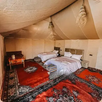 a bedroom with two beds in a tent at Desert Bloom Luxury Camp in Merzouga
