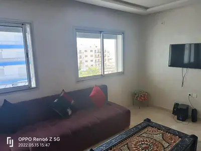 a living room with a couch and a flat screen tv at pool view 105 meters in Oulad Akkou