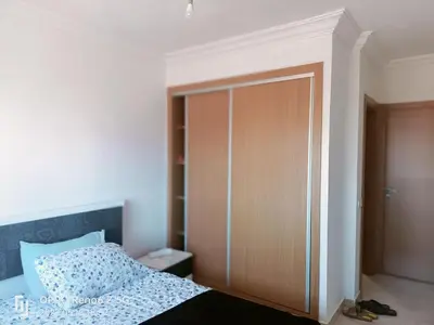 a bedroom with a bed and a wooden closet at pool view 105 meters in Oulad Akkou