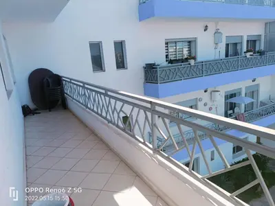 a balcony of a white building with a staircase at pool view 105 meters in Oulad Akkou
