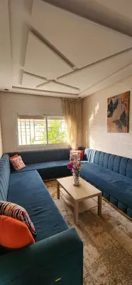 a living room with blue couches and a table at CHALEt VILLA PISCINE PRIVÉE in Imouzzer Kandar