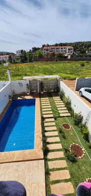 a swimming pool in the middle of a yard at CHALEt VILLA PISCINE PRIVÉE in Imouzzer Kandar