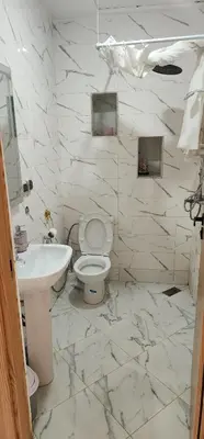 a white bathroom with a toilet and a sink at CHALEt VILLA PISCINE PRIVÉE in Imouzzer Kandar