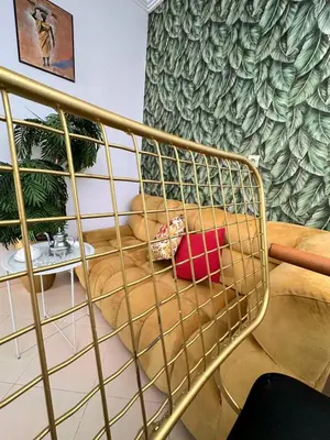 a gold railing in a living room with a couch at Maison individuelle lazaret in Oulad Akkou
