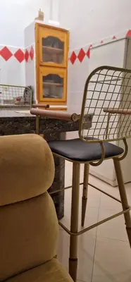 a chair sitting next to a counter with a cabinet at Maison individuelle lazaret in Oulad Akkou