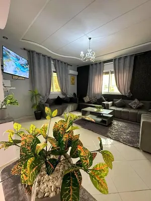 a living room with a couch and a tv at Maison individuelle lazaret in Oulad Akkou